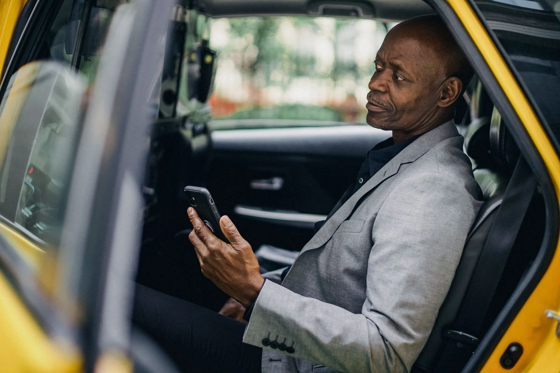 Passager utilisant une application de VTC sur smartphone à bord d'un taxi